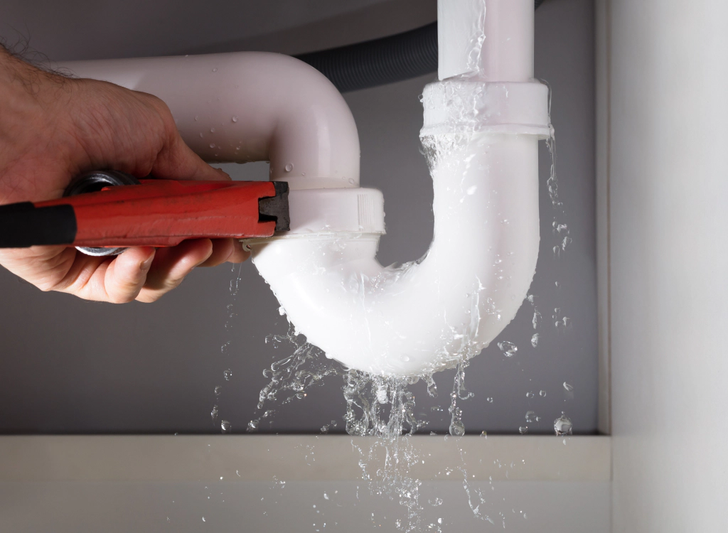 A person is using a hose to clean a pipe.